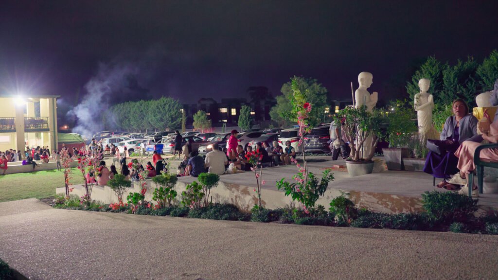 Khmer community gathering outdoors at Wat Buddharangsi Melbourne during an evening celebration