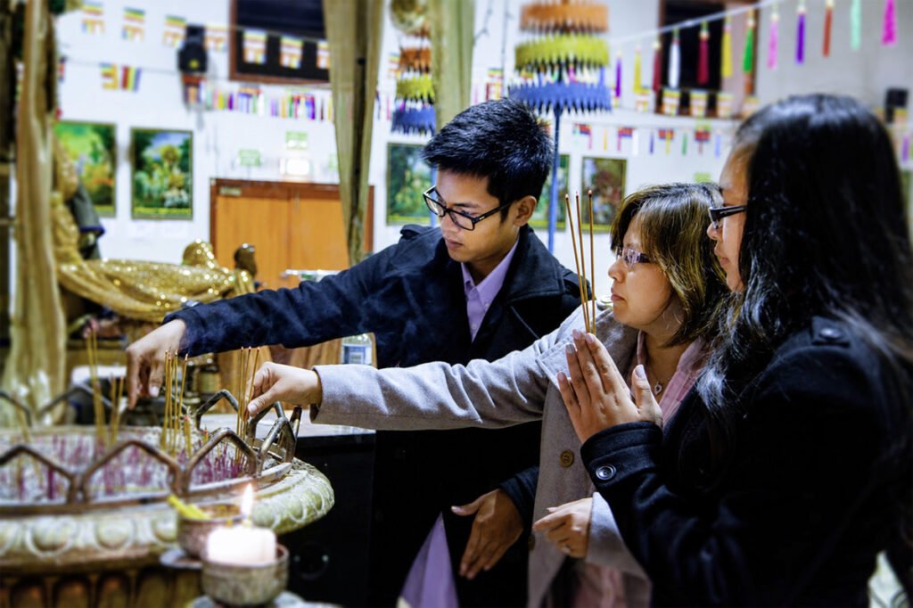 Family lighting incense and paying respect at Wat Buddharangsi Melbourne